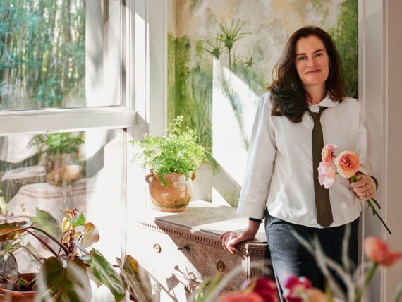 A woman surrounded by flowers in her home