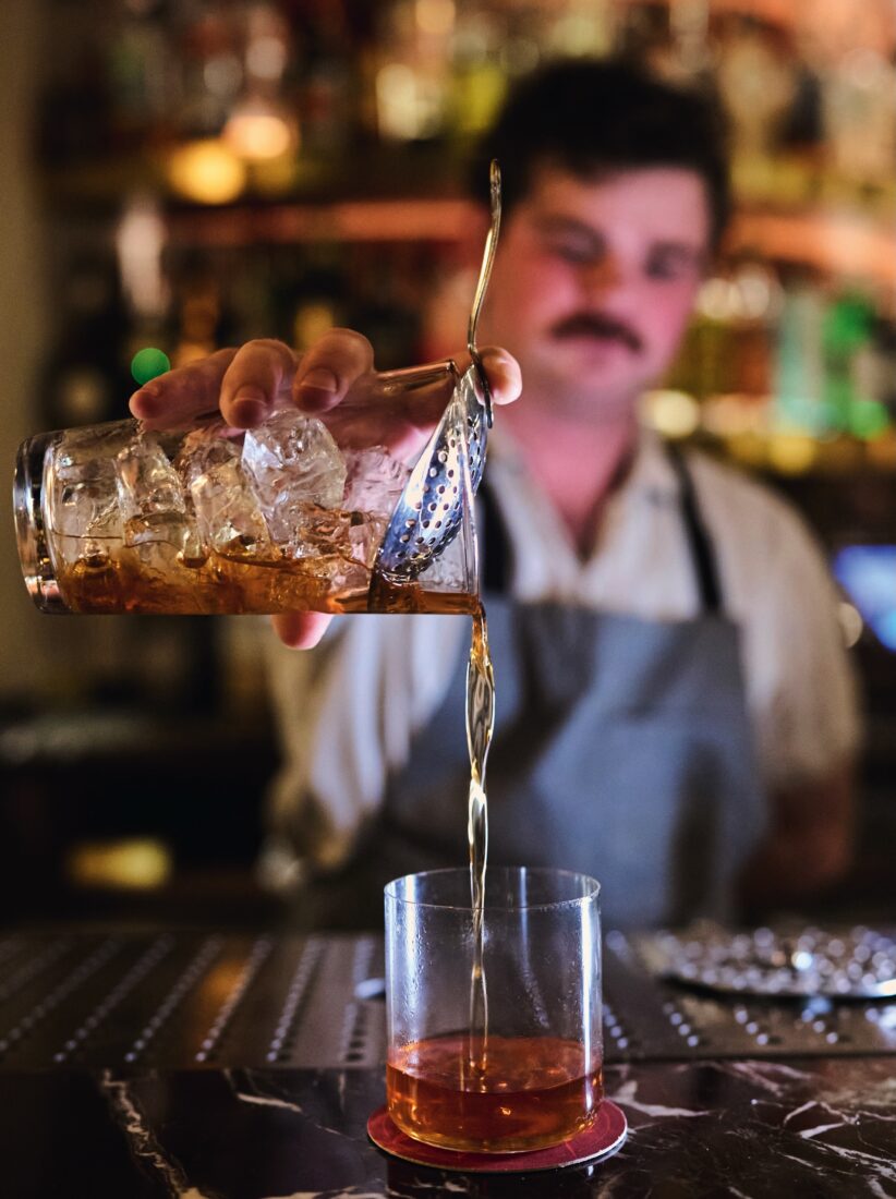 image of bartender pouring a Sazerac cocktail
