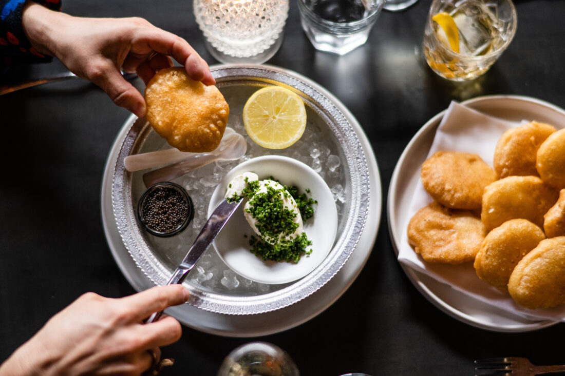 A tray of caviar and fried puffed pillows of potato and flour