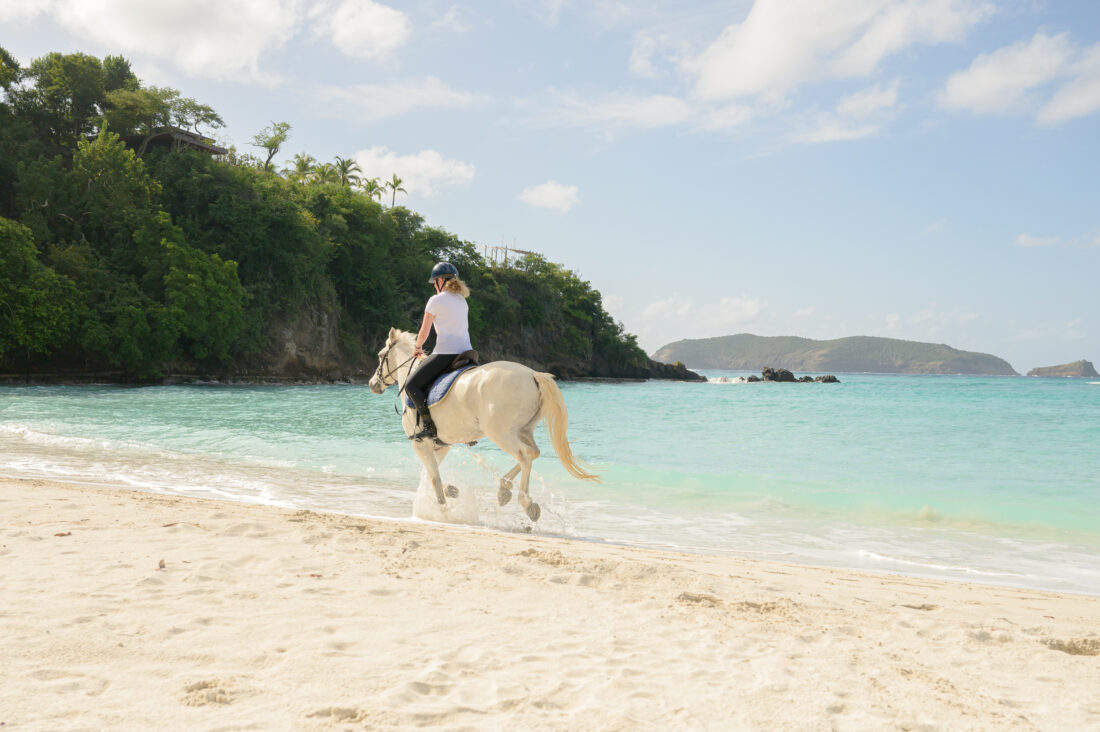 A person gallops along a beach