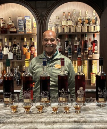 A man behind a bar with bourbon