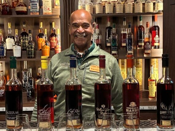 A man behind a bar with bourbon