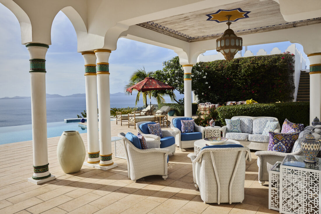 A patio with a pool and beach view