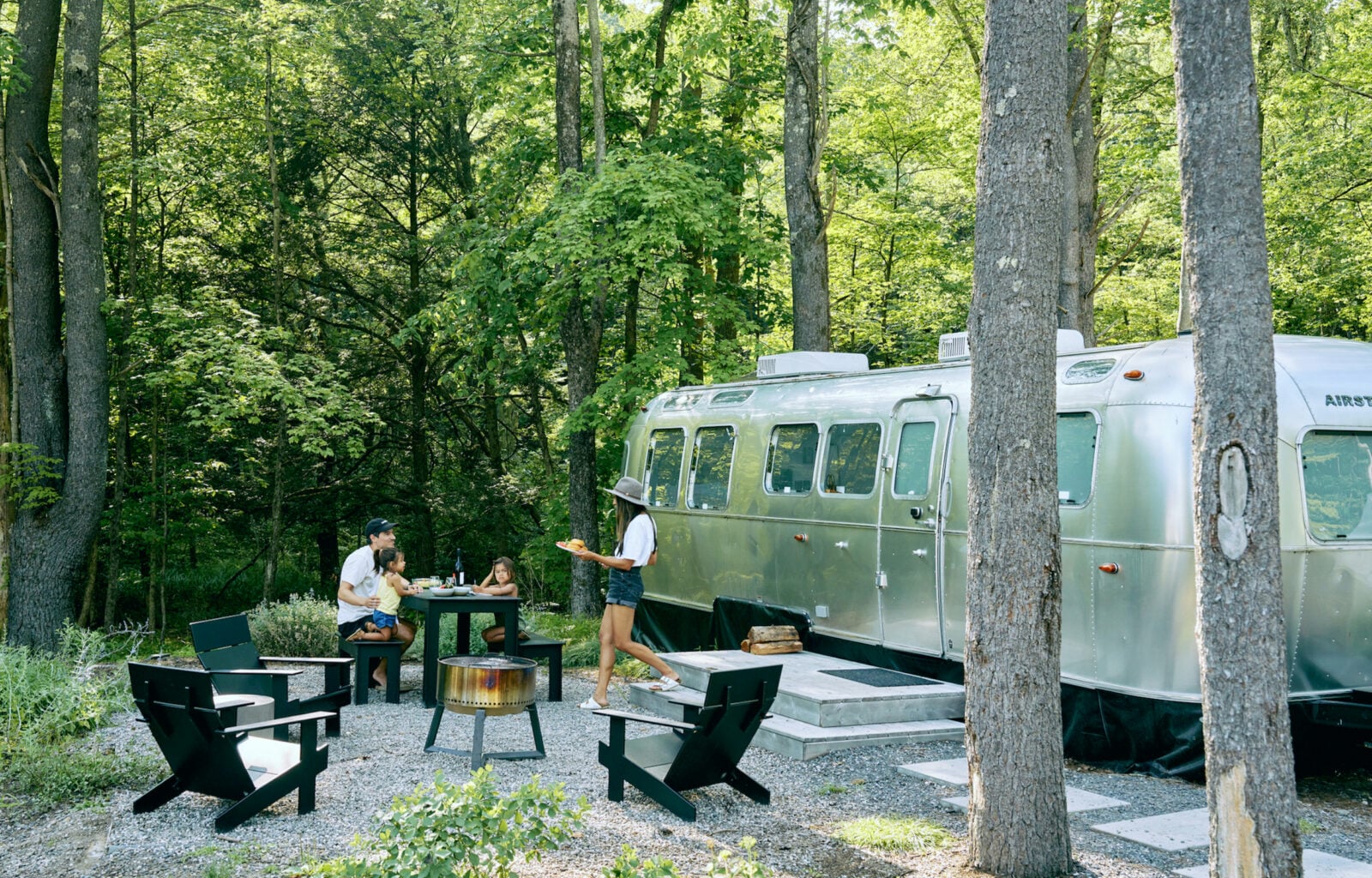 A family camps outside an airstream