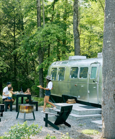 A family camps outside an airstream
