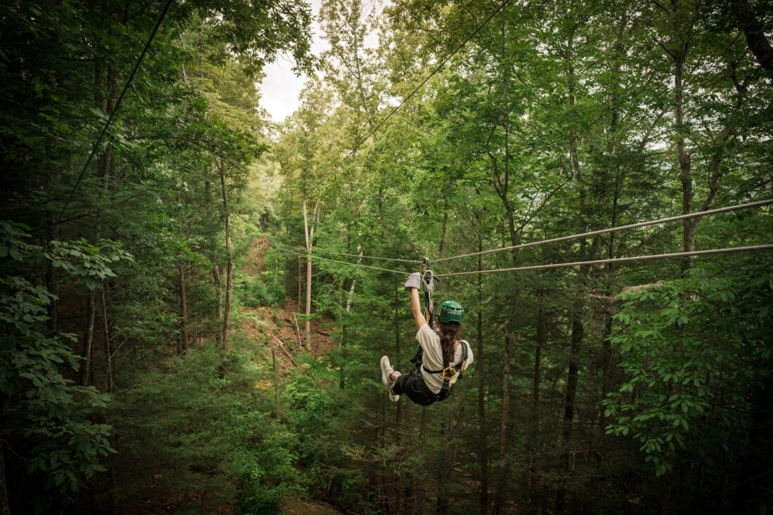A person ziplines through a gorge