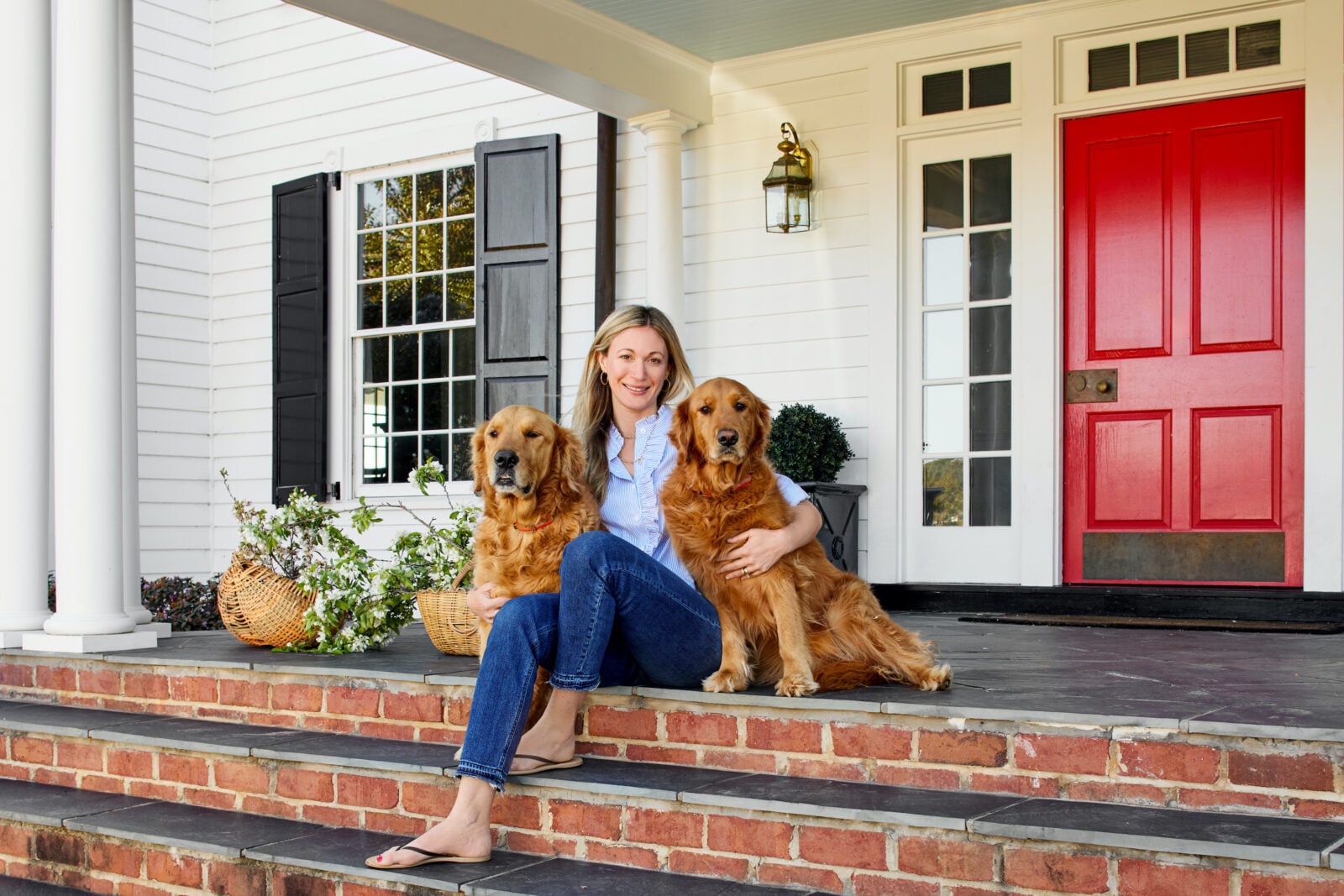 A woman with two golden retrievers