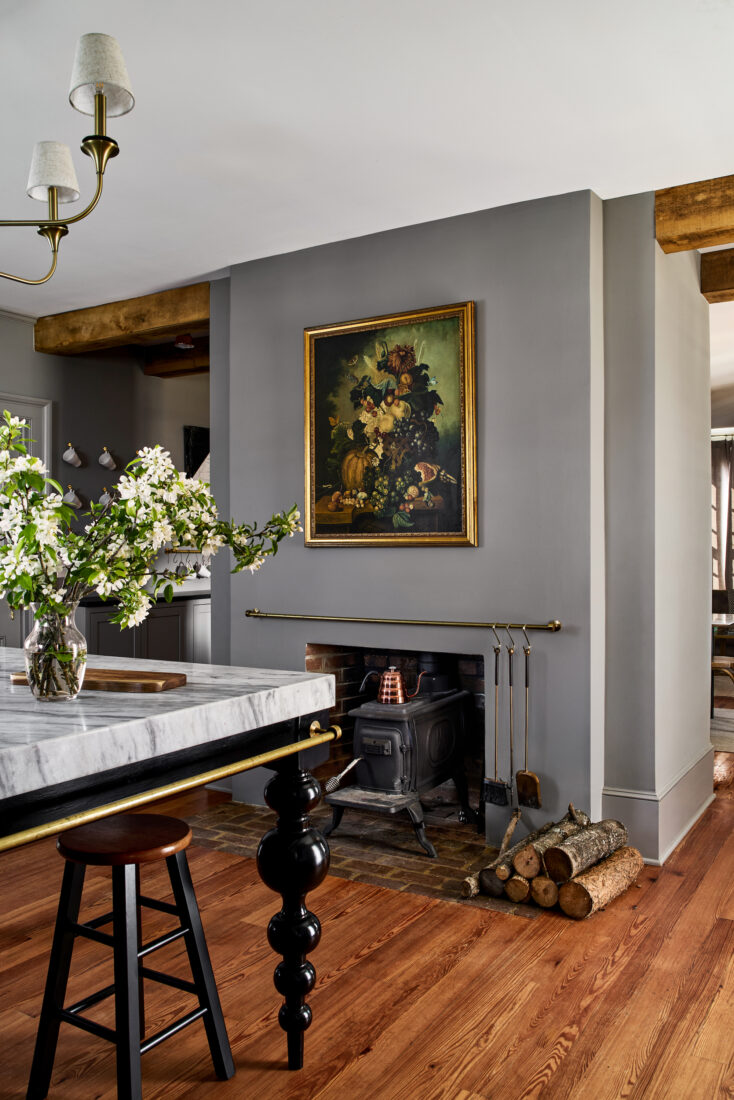 A grey-walled kitchen with a fireplace