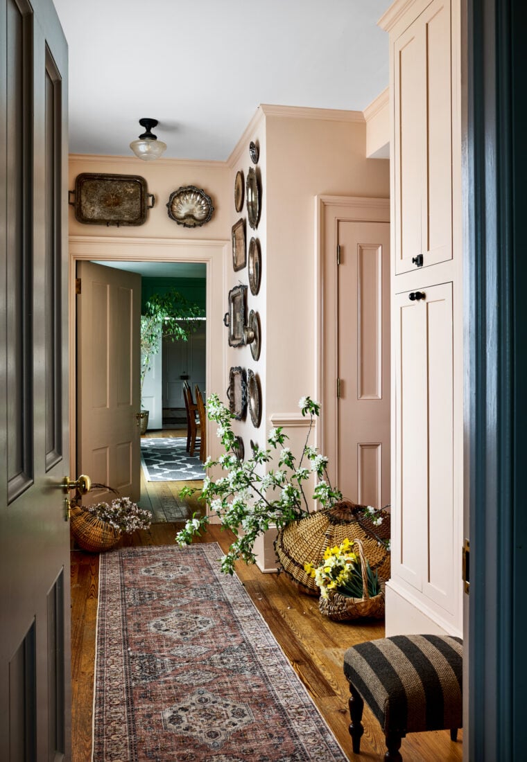 A pale pink pantry with silver platters on the wall
