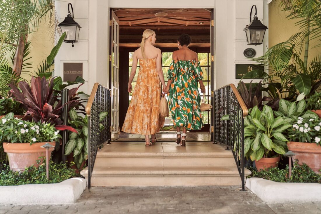 Two women in patterned dresses with shopping bags