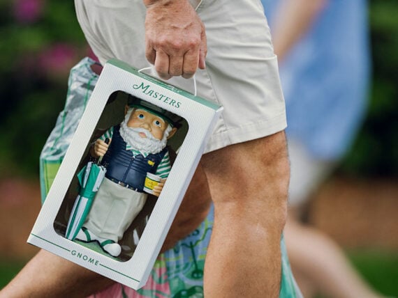 A person carries a garden gnome in a box