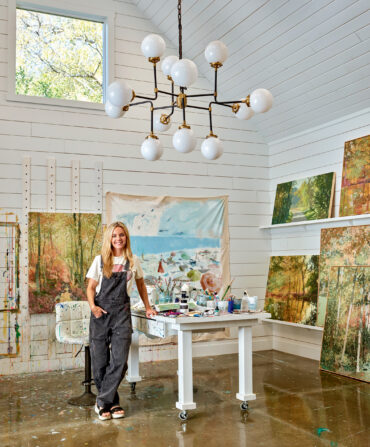 A woman inside an art studio with paintings