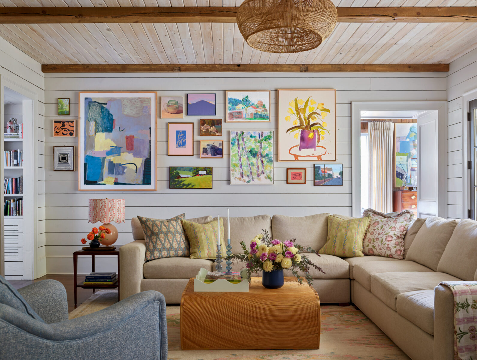 A colorful gallery wall over a sofa in a family room
