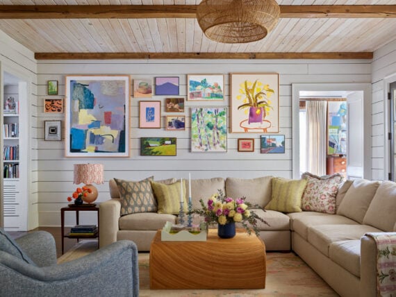 A colorful gallery wall over a sofa in a family room