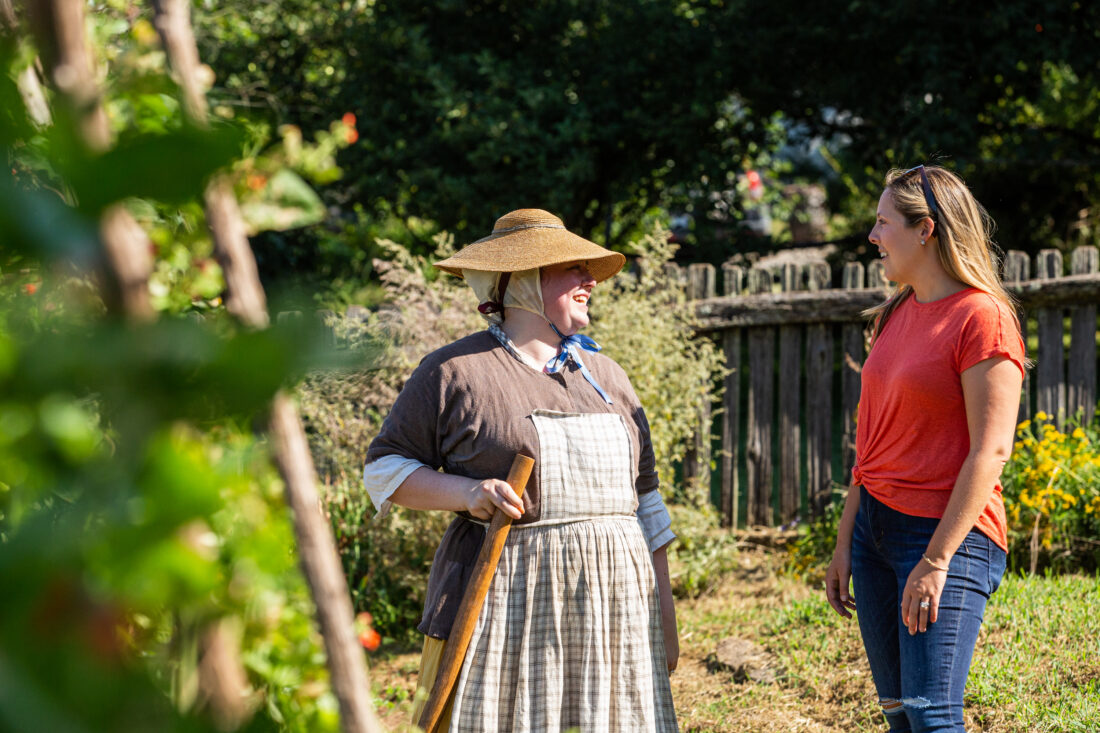 A costumed interpreter in a garden