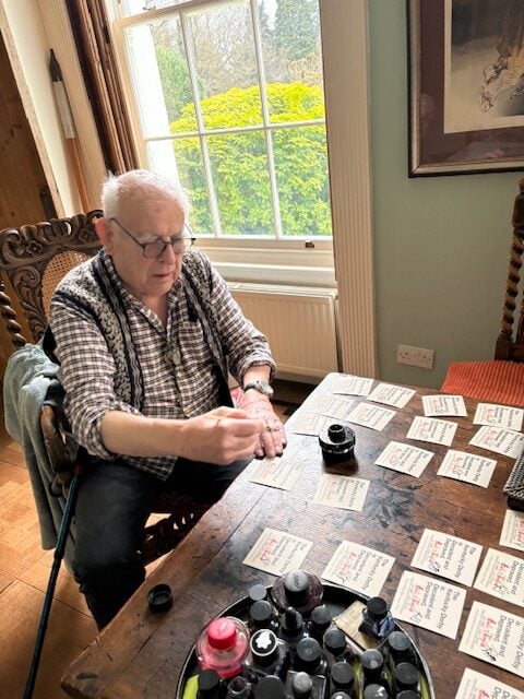 An artist signs labels in his studio