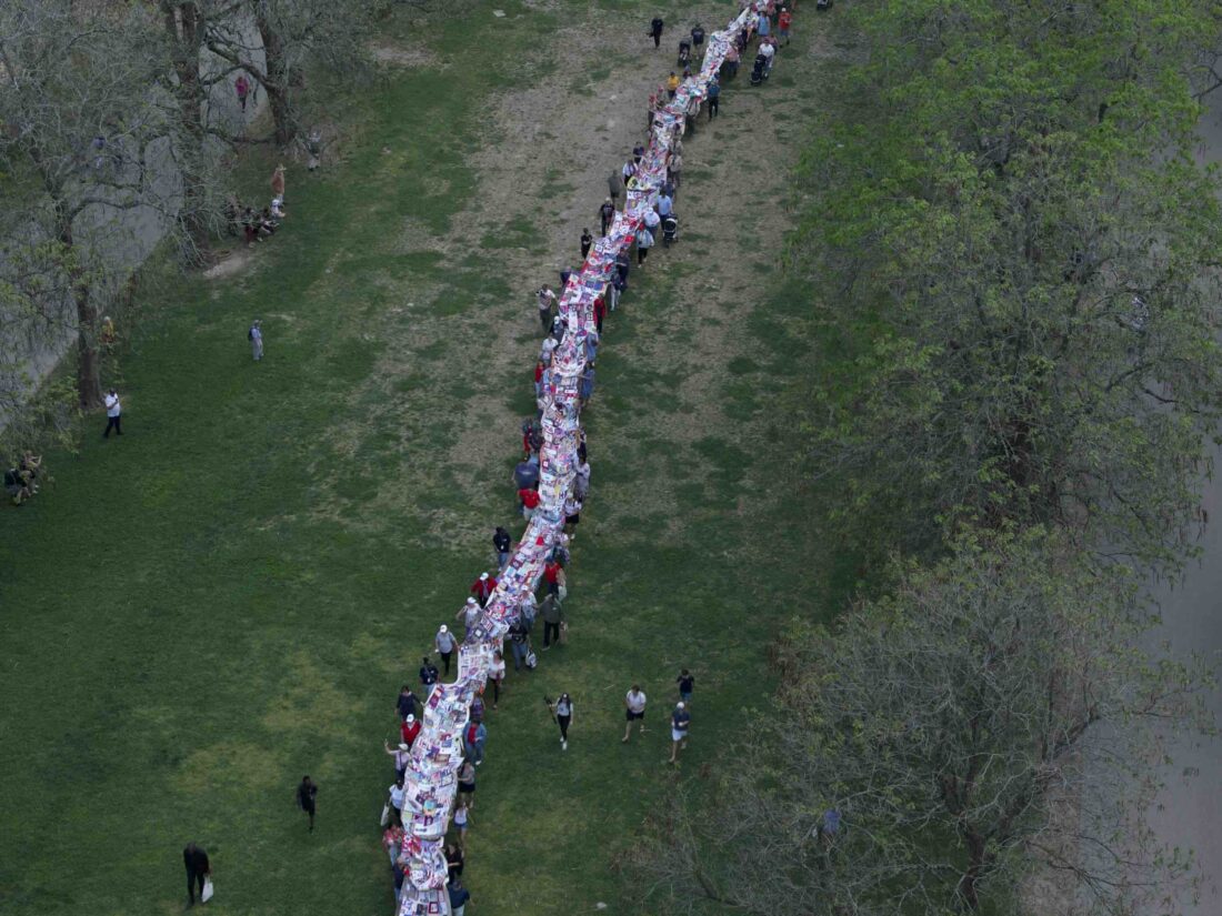 People hold a long quilt