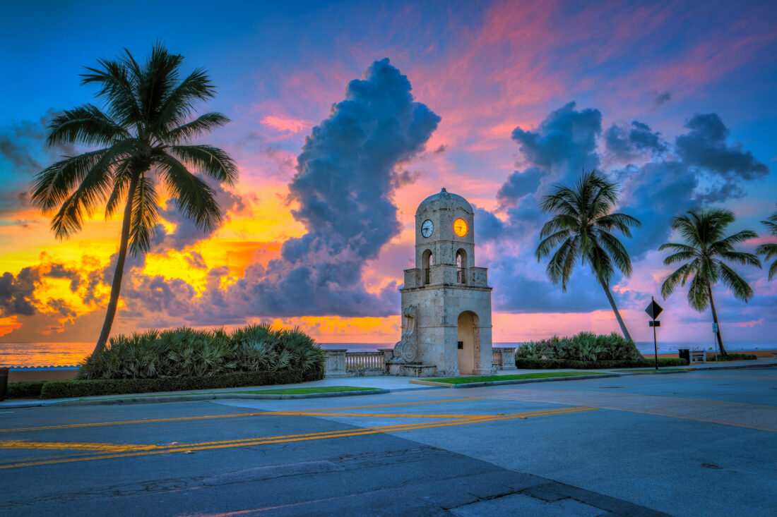 A clock tower at sunset by the water