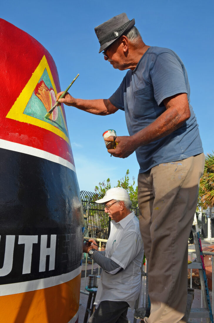 Painters touch up a buoy