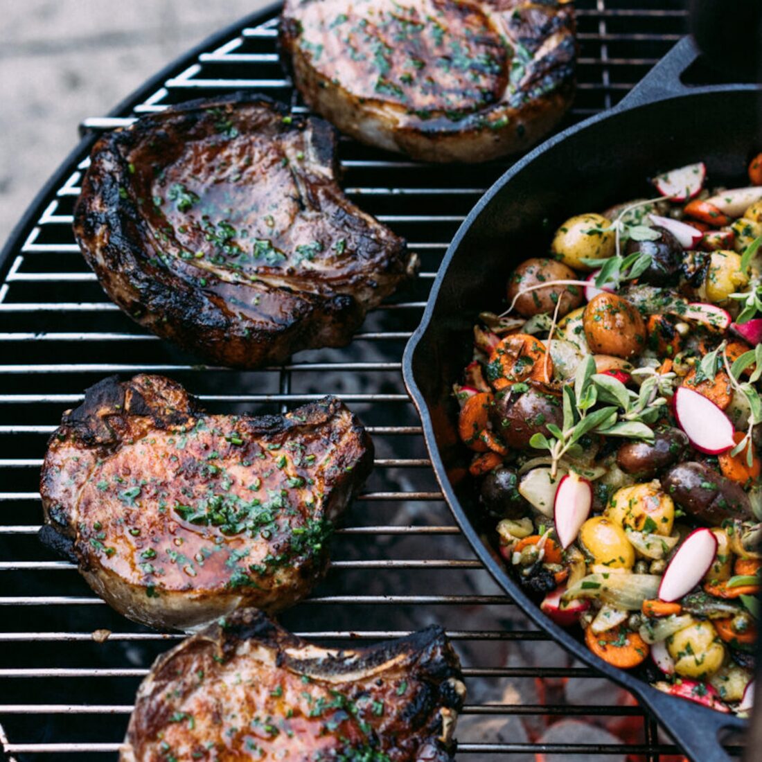 pork chops and roasted vegetables on a grill
