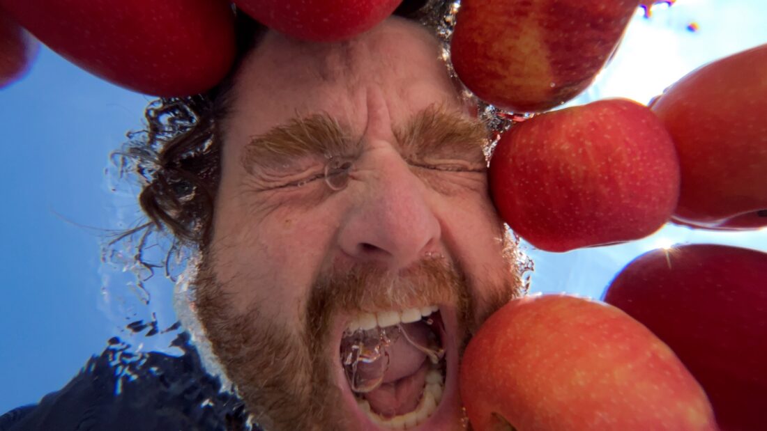 A man bobs for apples