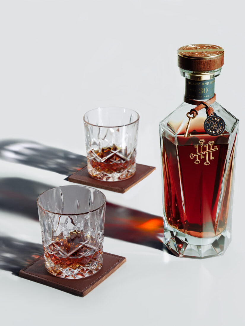 A bottle of bourbon with two glasses