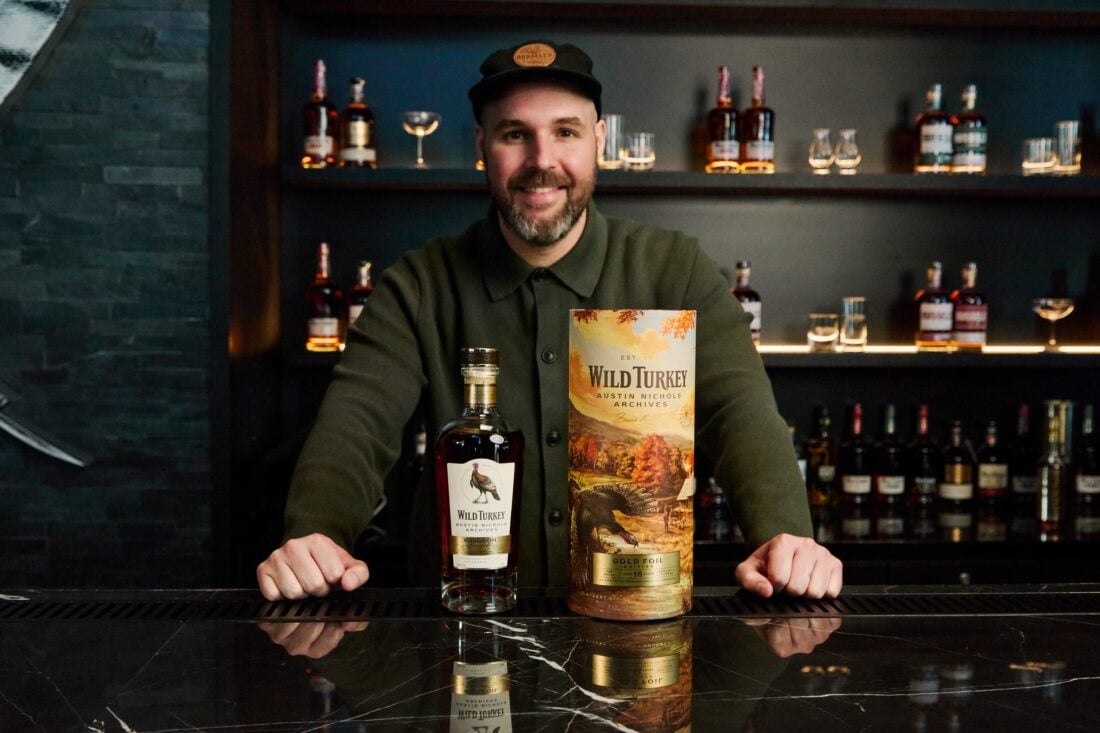 A portrait of a man with a bottle of bourbon