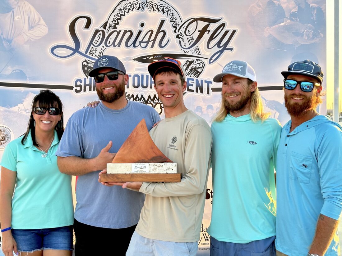 People hold a shark fishing award