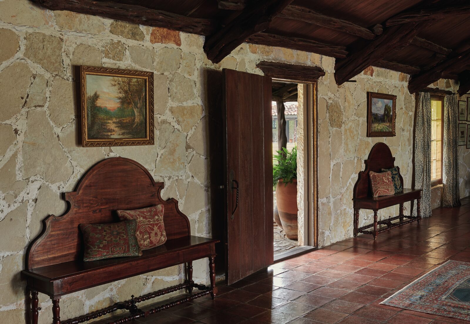 A stone home with a living room and wood benches