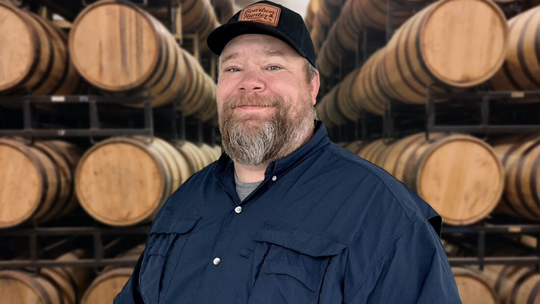 A portrait of a man with bourbon barrels