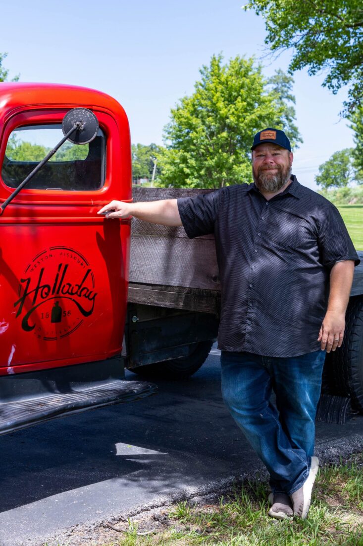 A man stands by a red truck