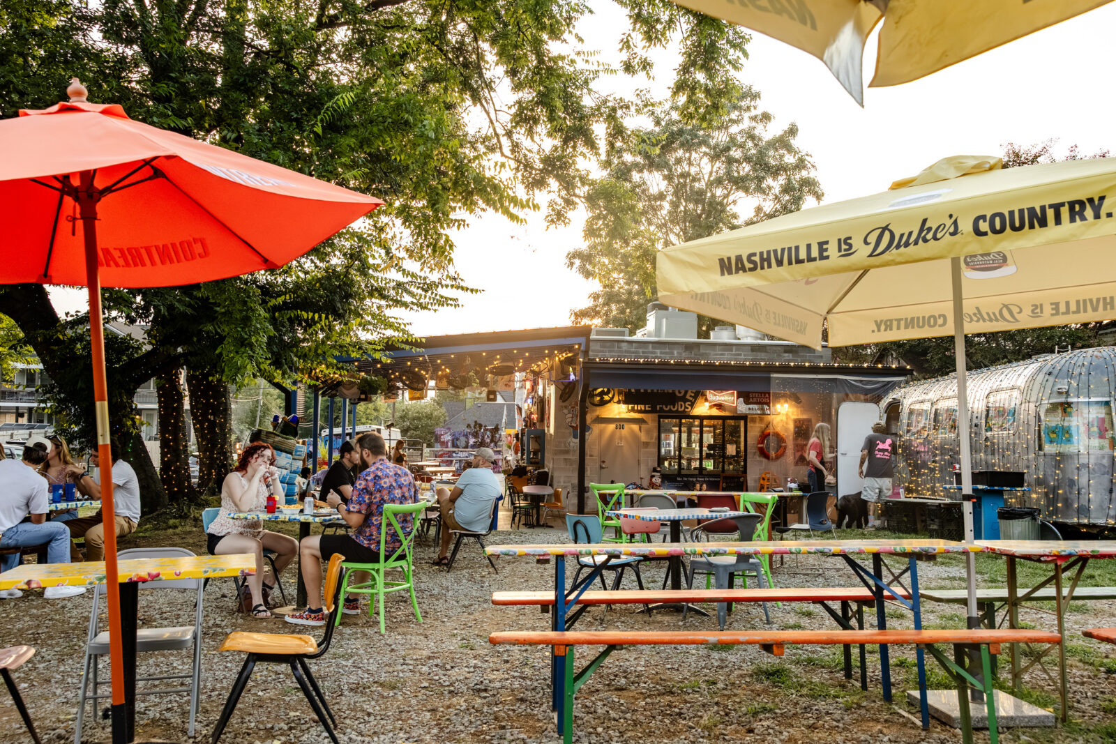 Colorful benches, tables, chairs, and umbrellas in an outdoor restaurant