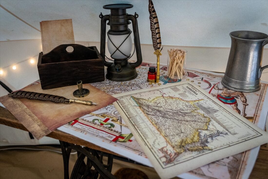 image of an old writing desk with quills and papers