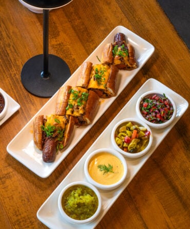 A plates with condiments and hot dogs