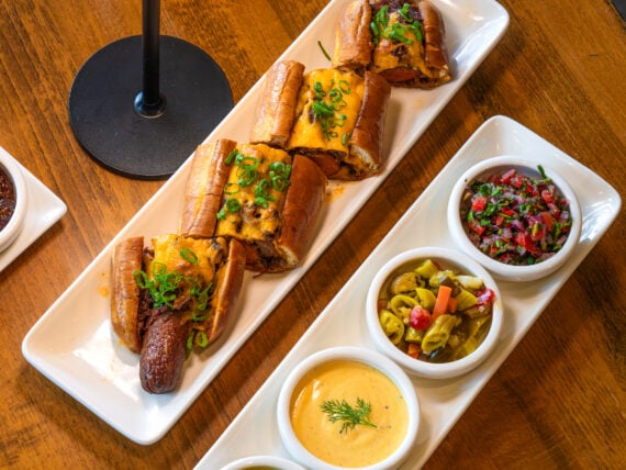 A plates with condiments and hot dogs