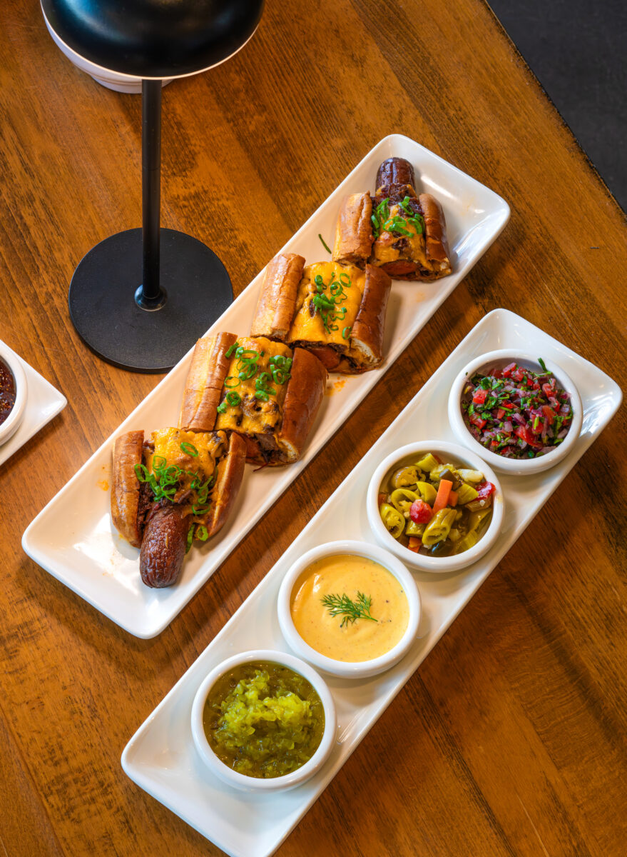 A plates with condiments and hot dogs