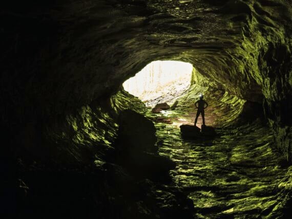 A man stands inside a cave