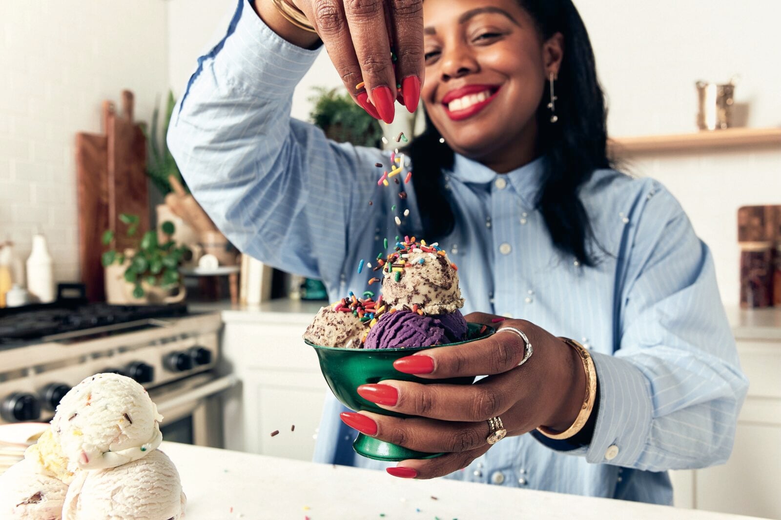 A woman sprinkles sprinkles onto ice cream