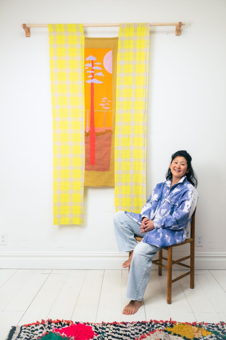 An artist with a fabric window artwork