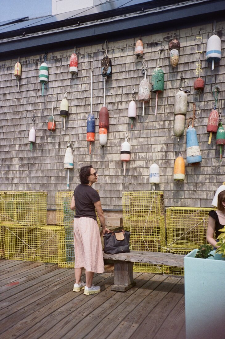 A woman looks at buoys on a wall