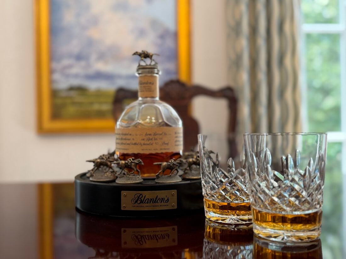 A bottle of bourbon and two glasses