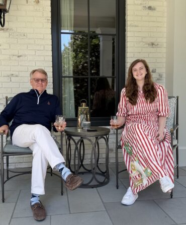 A man and woman sit on a porch