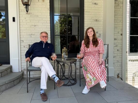 A man and woman sit on a porch