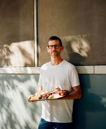 A man holds a plate of BBQ