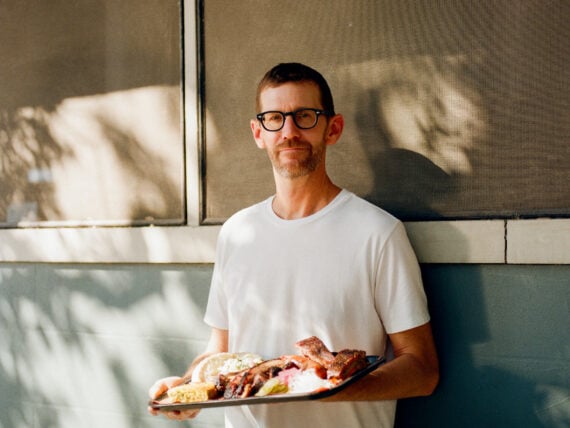 A man holds a plate of BBQ
