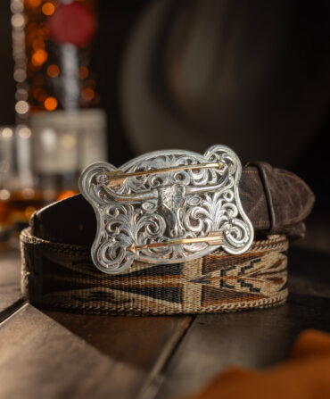 A silver belt buckle on a leather belt