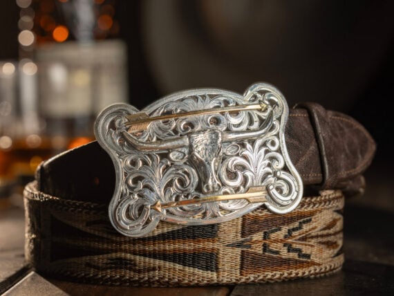 A silver belt buckle on a leather belt