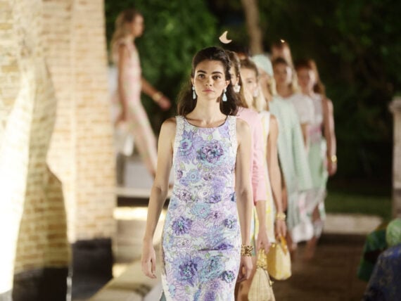 a woman in a purple dress walks the runway