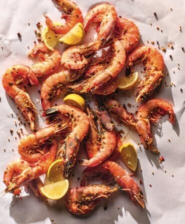 Cooked shrimp with lemon on a white background