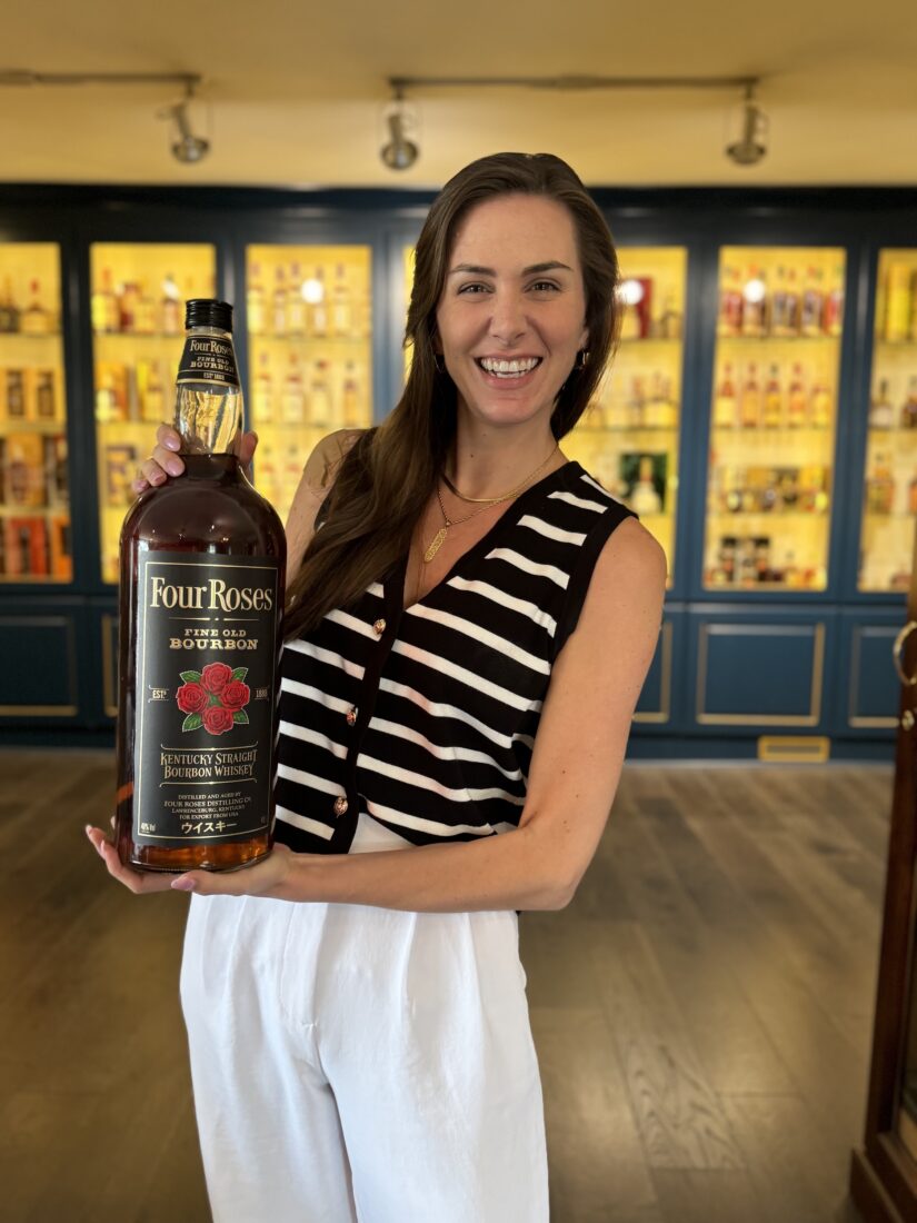 A woman holds a bottle of bourbon